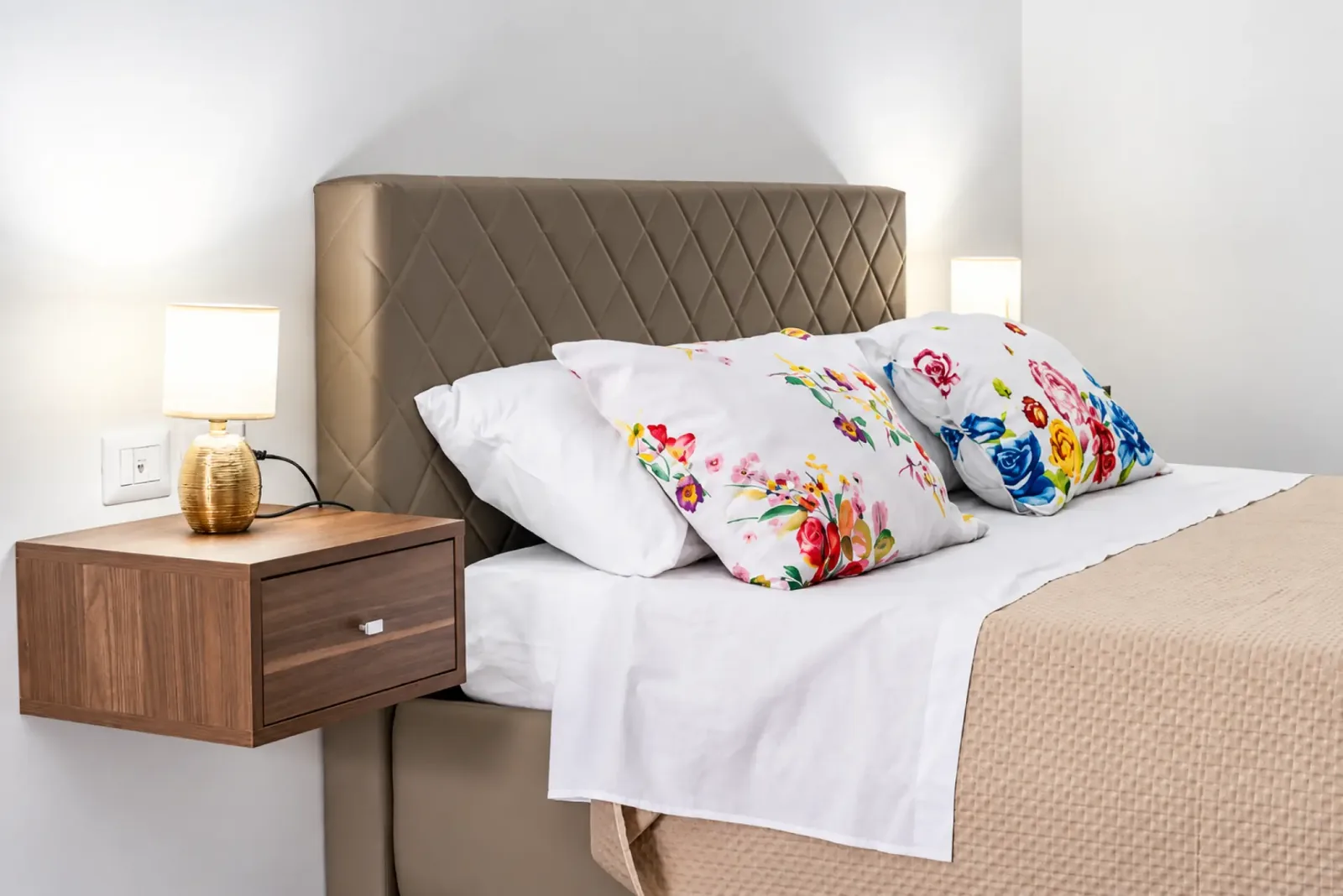 Letto della camera con cuscini floreali